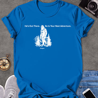 He's Out There. So Is Your Next Adventure - Oregon | Unisex Softstyle T-Shirt | Oregon Bigfoot Travel Tee